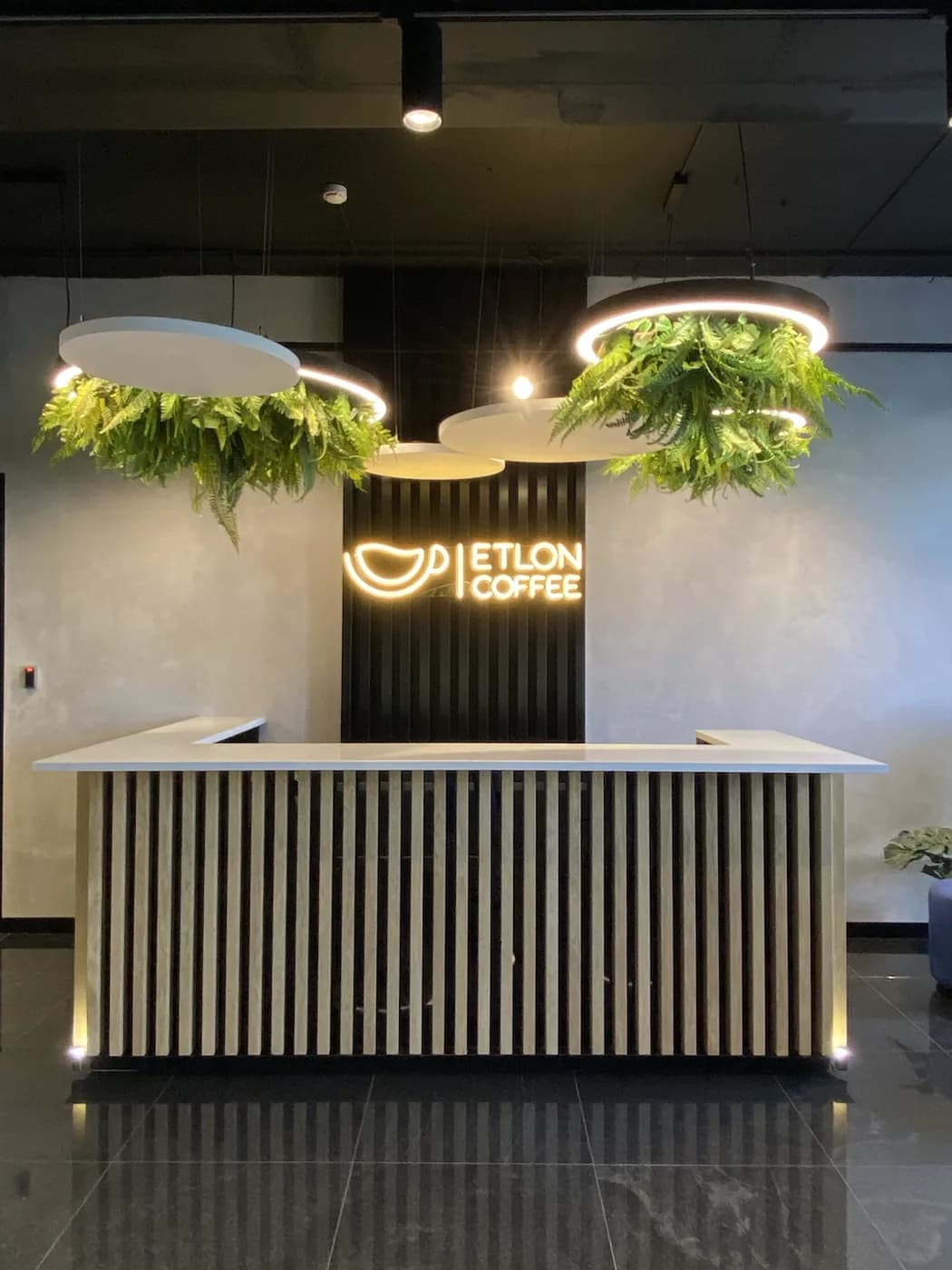 Неоновая вывеска Etlon Coffee с логотипом-чашкой в зоне отдыха кофейни в Санкт-Петербурге