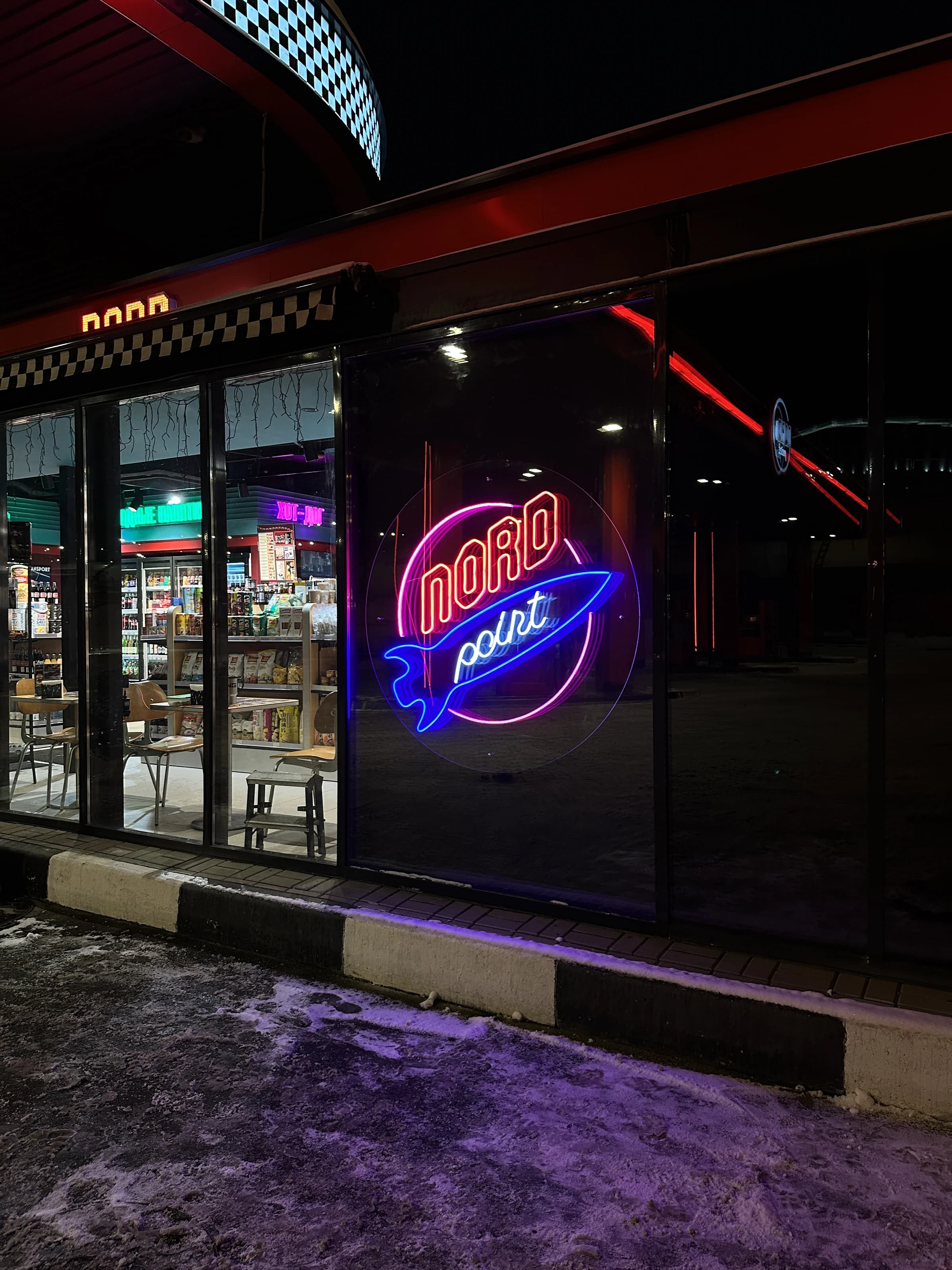 Круглый неоновый логотип Nord point за стеклом витрины, Санкт-Петербург