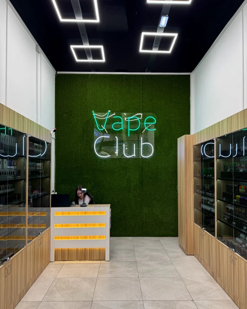 Неоновая вывеска Vape Club на зелёной стене в зале магазина, ТРЦ «ЭкоПарк», Мурино