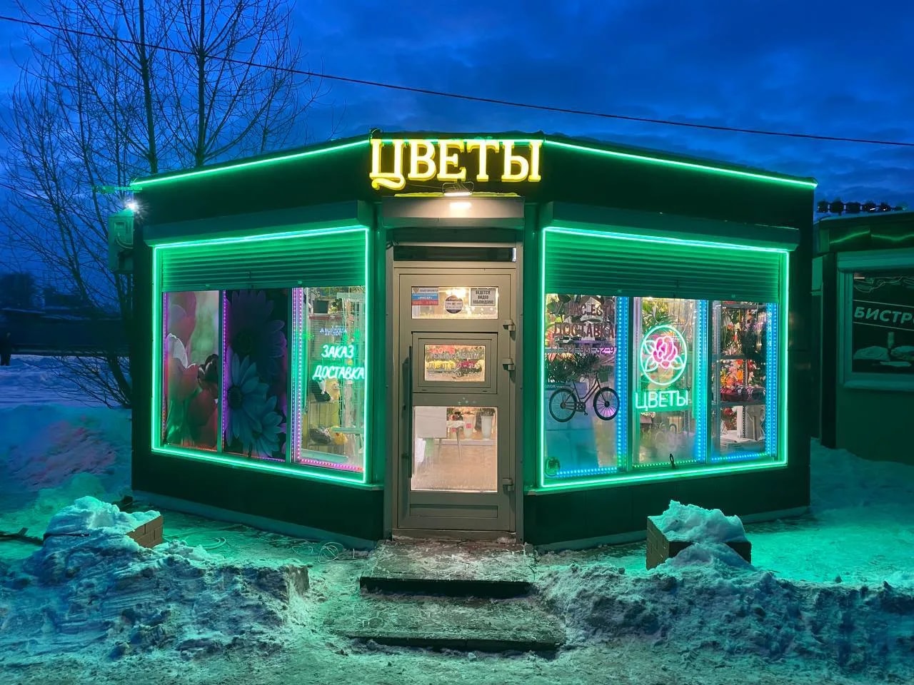Неоновые вывески «Цветы» и неон про доставку, зелёный контур по фризу и окнам цветочного «Восторг», пос. Сапёрный, Невская ул., 1